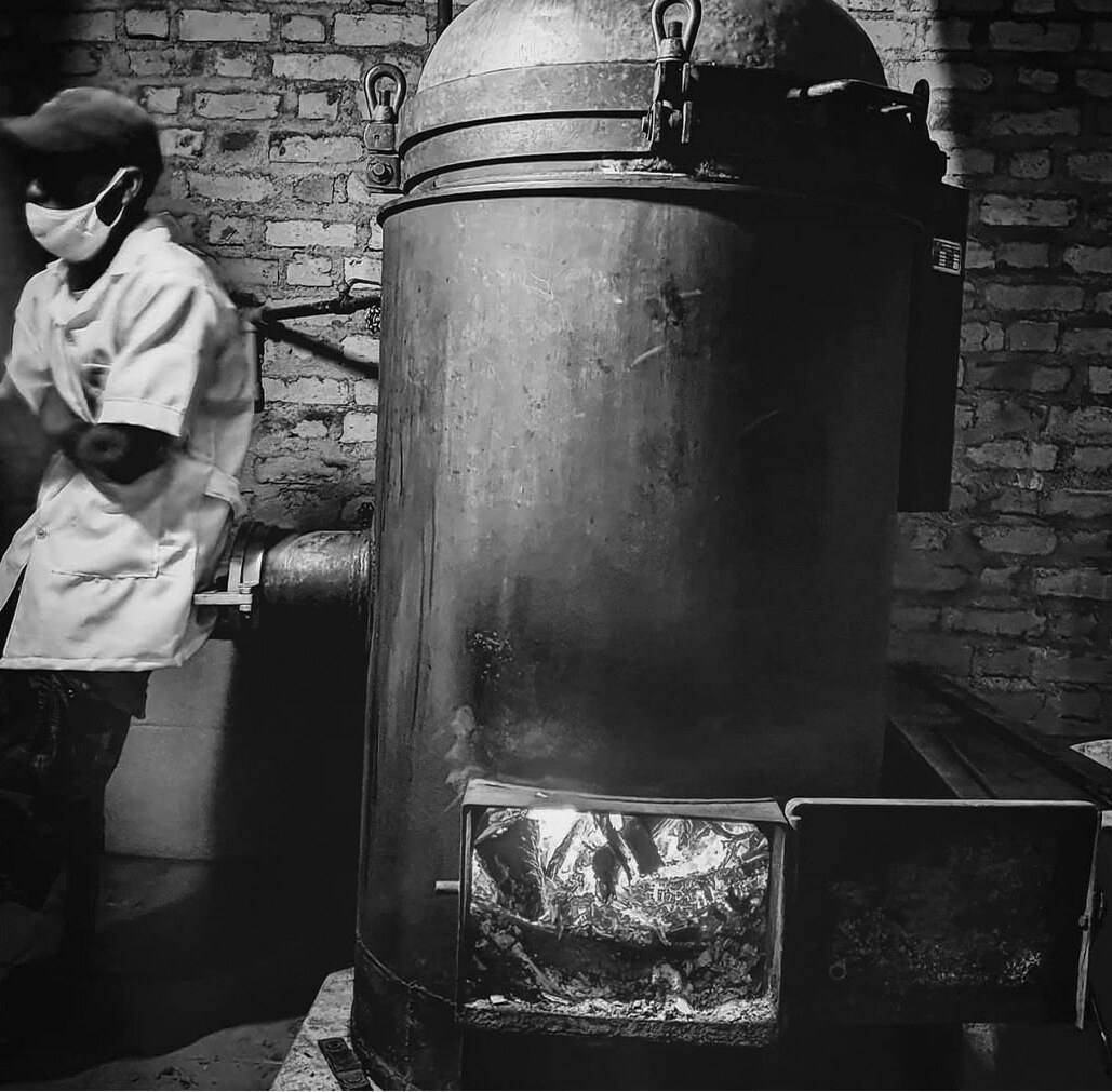 Un distillateur devant l’alambic, feu allumé